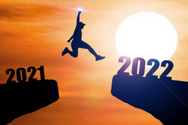 Mutlu yıllar 2022 Siluet resmi 2021 'den 2022' ye kadar güzel gökyüzünde mutlu bir adam.