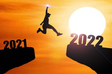 Mutlu yıllar 2022 Siluet resmi 2021 'den 2022' ye kadar güzel gökyüzünde mutlu bir adam.