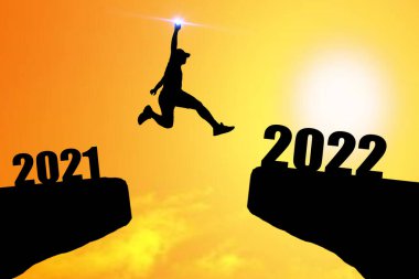 Mutlu yıllar 2022 Siluet resmi 2021 'den 2022' ye kadar güzel gökyüzünde mutlu bir adam.