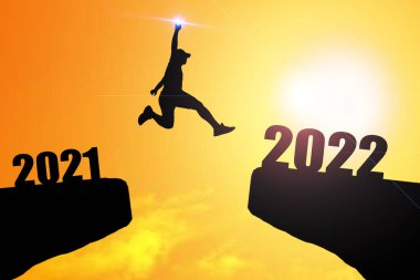Mutlu yıllar 2022 Siluet resmi 2021 'den 2022' ye kadar güzel gökyüzünde mutlu bir adam.