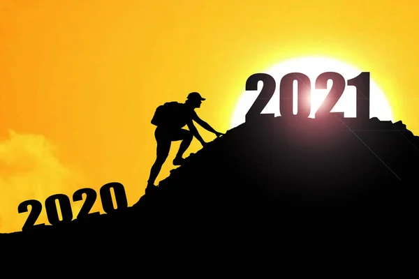 在2021年欢迎快乐的圣诞和快乐的新年 轮廓人从2020悬崖到2021悬崖与云天和阳光 男子手持2021年的旗帜在山顶上 二零零一新年快乐概念 — 图库照片