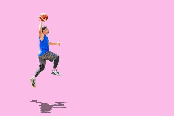 アジアのバスケットボール選手ジャンプダンクで得点上の色の背景 — ストック写真