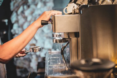 Kahve makinesinden kahve yapan barista.