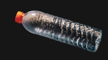Siyah zemin üzerinde yüzen plastik su şişesi projelerde kolayca kullanılabilir. Suya saçılmış plastik atık. Atık ve plastik kirliliği kavramı