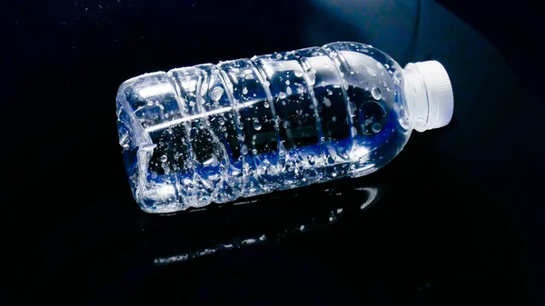 黒い背景に水に浮かぶプラスチック製のウォーターボトルは プロジェクトで簡単に使用できます プラスチック廃棄物が水の上に流れます 廃棄物やプラスチック汚染の概念 — ストック写真