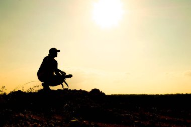 Profesyonel bir manzara fotoğrafçısının silueti dağda bir kamera tutuyor..