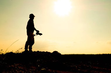 Profesyonel bir manzara fotoğrafçısının silueti dağda bir kamera tutuyor..