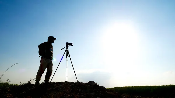 ジェスチャーシルエット プロの風景旅行写真家が山の上で写真を撮る — ストック写真