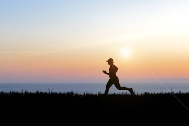 Akşamları antrenman yapan bir koşucunun silueti. Coronavirüs krizinden sonra eğitim fikirleri