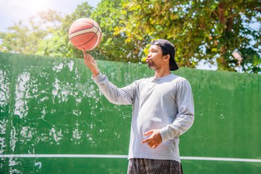 26 Haziran 2021 'de COVID-19 krizi sırasında dışarıda basketbol oynayarak egzersiz yapan adam, Surat Thani, Tayland.