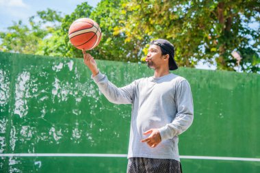 26 Haziran 2021 'de COVID-19 krizi sırasında dışarıda basketbol oynayarak egzersiz yapan adam, Surat Thani, Tayland.