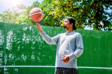 26 Haziran 2021 'de COVID-19 krizi sırasında dışarıda basketbol oynayarak egzersiz yapan adam, Surat Thani, Tayland.