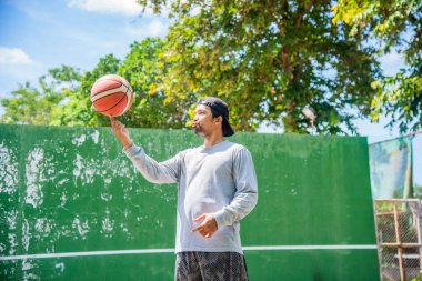 26 Haziran 2021 'de COVID-19 krizi sırasında dışarıda basketbol oynayarak egzersiz yapan adam, Surat Thani, Tayland.