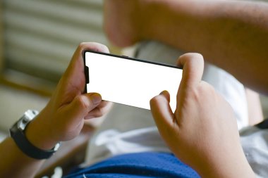 Uyuyan bir adamın elleri rahat bir şekilde cep telefonuyla oyun oynuyor.