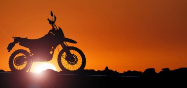 Akşamları maceracı bir turistin motosikletinin silüeti..