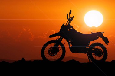 Akşamları maceracı bir turistin motosikletinin silüeti..