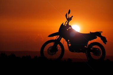 Akşamları maceracı bir turistin motosikletinin silüeti..