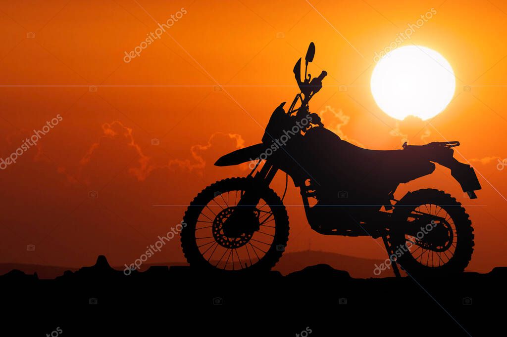 Silhouette of a motocross motorcycle of an adventurous tourist in the evening.
