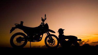 Siluet fotoğrafçısı akşamları motosikletli off-road ya da motokroslu maceralar. seyahat ve macera kavramı