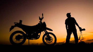 Siluet fotoğrafçısı akşamları motosikletli off-road ya da motokroslu maceralar. seyahat ve macera kavramı