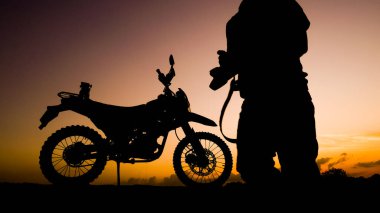 Akşamları motosikletle, motosikletle ya da motokrosla macera yaşayan turistlerin silueti. - Evet. seyahat ve macera kavramı