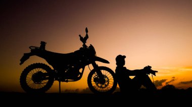 Siluet fotoğrafçısı akşamları motosikletli off-road ya da motokroslu maceralar. seyahat ve macera kavramı