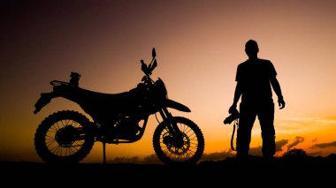 Siluet fotoğrafçısı akşamları motosikletli off-road ya da motokroslu maceralar. seyahat ve macera kavramı