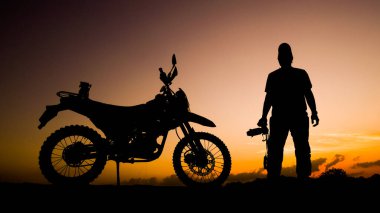 Siluet fotoğrafçısı akşamları motosikletli off-road ya da motokroslu maceralar. seyahat ve macera kavramı