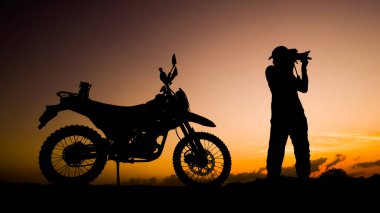 Siluet fotoğrafçısı akşamları motosikletli off-road ya da motokroslu maceralar. seyahat ve macera kavramı