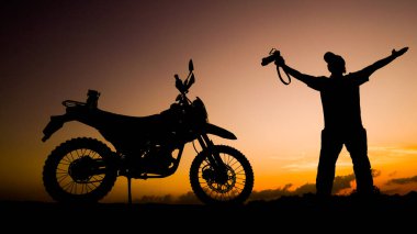 Siluet fotoğrafçısı akşamları motosikletli off-road ya da motokroslu maceralar. seyahat ve macera kavramı