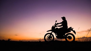 Akşamları motosikletle, motosikletle ya da motokrosla macera yaşayan turistlerin silueti. - Evet. seyahat ve macera kavramı
