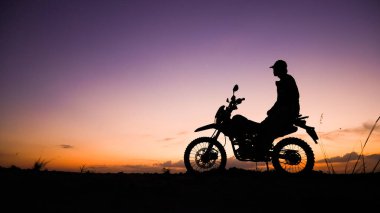 Akşamları motosikletle, motosikletle ya da motokrosla macera yaşayan turistlerin silueti. - Evet. seyahat ve macera kavramı