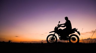 Akşamları motosikletle, motosikletle ya da motokrosla macera yaşayan turistlerin silueti. - Evet. seyahat ve macera kavramı