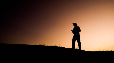 Tepedeki adamın siluetleri, seyahat ve macera konsepti