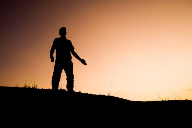 Tepedeki adamın siluetleri, seyahat ve macera konsepti