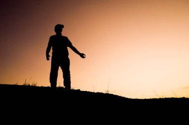 Tepedeki adamın siluetleri, seyahat ve macera konsepti