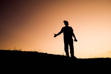 Tepedeki adamın siluetleri, seyahat ve macera konsepti