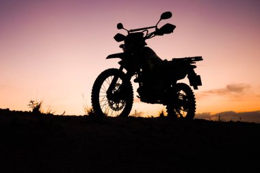 Akşamları arazi motosikleti ya da motokros silueti. seyahat ve macera kavramı