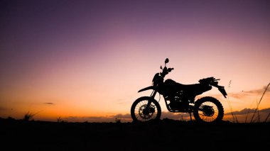 Akşamları arazi motosikleti ya da motokros silueti. seyahat ve macera kavramı