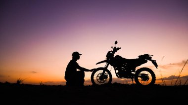 Akşamları motosikletle, motosikletle ya da motokrosla macera yaşayan turistlerin silueti. - Evet. seyahat ve macera kavramı