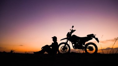 Akşamları motosikletle, motosikletle ya da motokrosla macera yaşayan turistlerin silueti. - Evet. seyahat ve macera kavramı