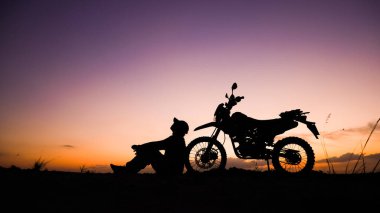 Akşamları motosikletle, motosikletle ya da motokrosla macera yaşayan turistlerin silueti. - Evet. seyahat ve macera kavramı