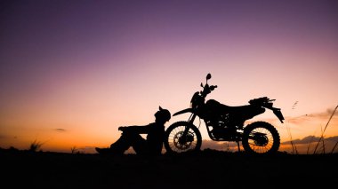 Akşamları motosikletle, motosikletle ya da motokrosla macera yaşayan turistlerin silueti. - Evet. seyahat ve macera kavramı