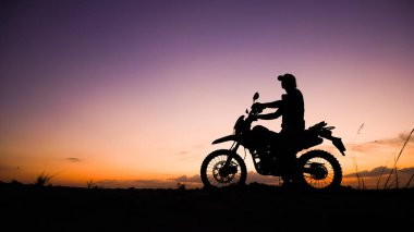 Akşamları motosikletle, motosikletle ya da motokrosla macera yaşayan turistlerin silueti. - Evet. seyahat ve macera kavramı