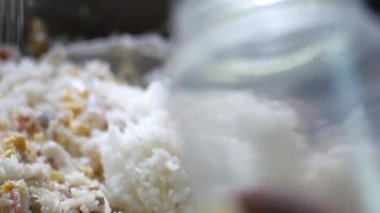 Tavada yemek pişiren kadına yaklaş.