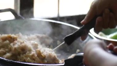 Tavada yemek pişiren kadına yaklaş.