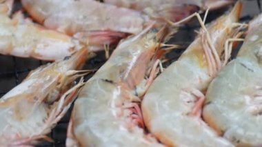 Lezzetli Asya yemeklerini, ızgaradaki karidesleri yakından izleyin.