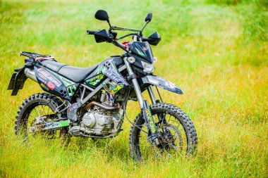 Kawasaki motokros motosikleti 21 Temmuz 2021 'de bir araziye park edilmiş, Surat Thani, Tayland.