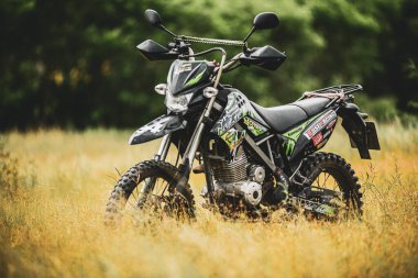 Kawasaki motokros motosikleti 21 Temmuz 2021 'de bir araziye park edilmiş, Surat Thani, Tayland.