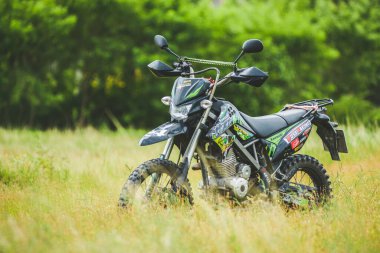 Kawasaki motokros motosikleti 21 Temmuz 2021 'de bir araziye park edilmiş, Surat Thani, Tayland.